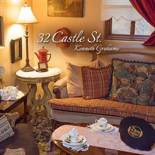 32-Castle-St-Kenneth-Grahame-Seating-Area-Teatime-Parlor-The-St-James-Tearoom Cozy tearoom parlor seating area with a patterned sofa, table lamp, and set tea table
