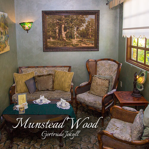 Munstead-Wood-Gertrude-Jekyll-Seating-Area-Teatime-Parlor-The-St-James-Tearoom Vintage styled seating nook with sage green walls, decorative pillows, and a butterfly lamp