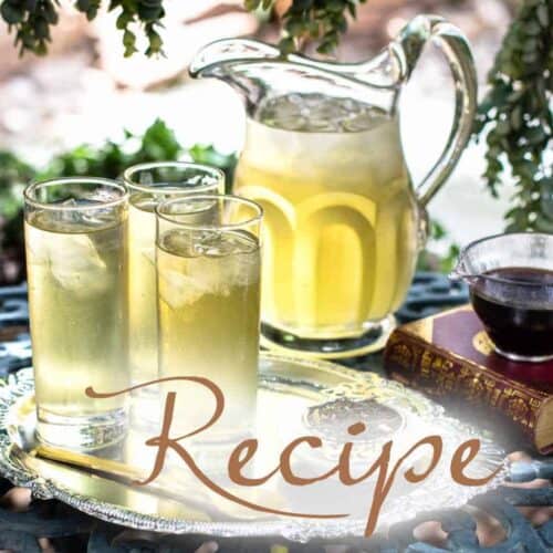 A tray with three glasses of iced yellow drink, a glass pitcher, and a small cup on a book sits on a metal table outdoors. The word “Iced Tea Recipe” is overlaid on the image.