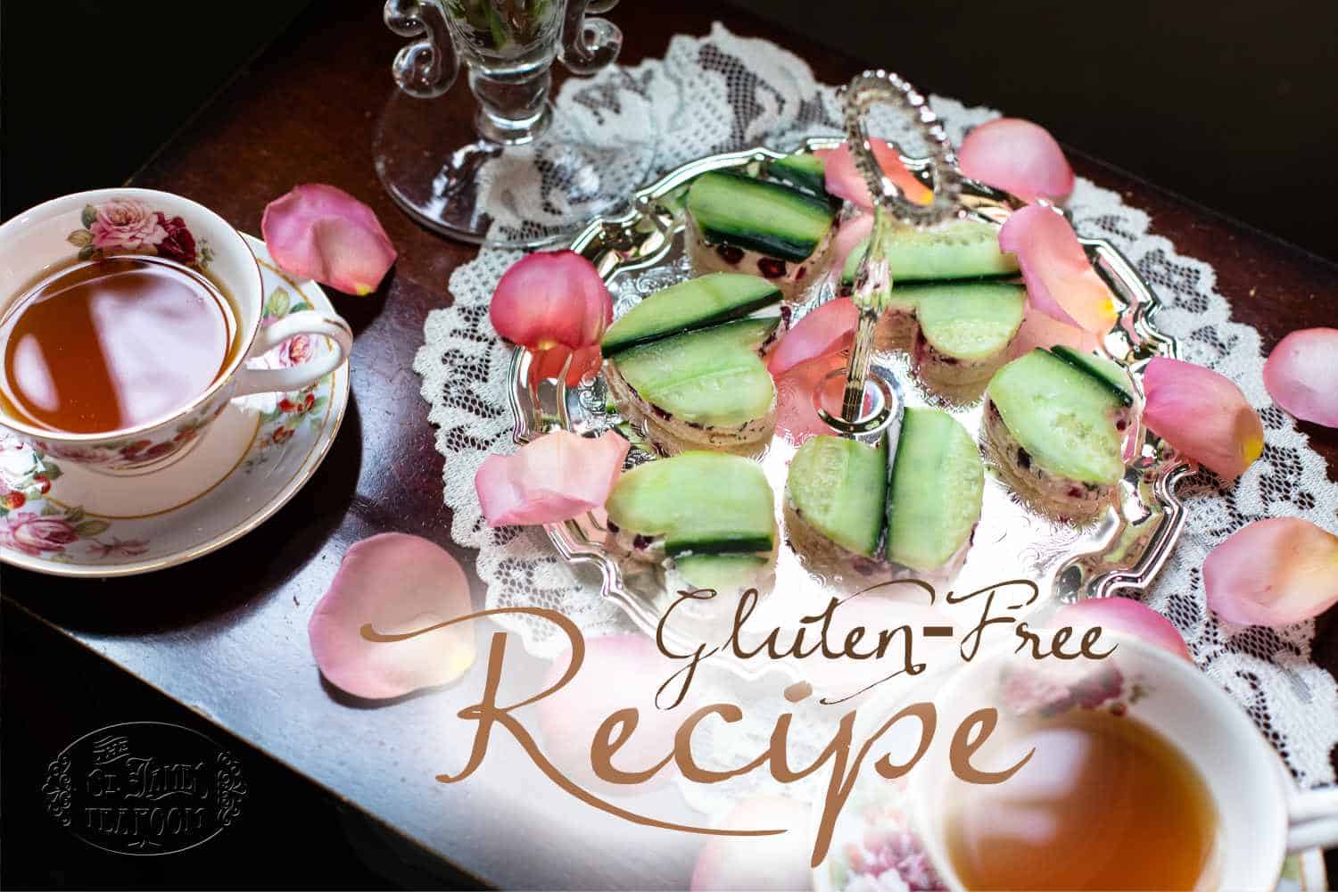 A silver tray with cucumber tea sandwiches and rose petals, next to a teacup on a lace doily. Text reads “Gluten-Free Recipe.” Discover more delights like our Quick and Easy Chocolate Cherry Scone Recipe from The St. James Tearoom.