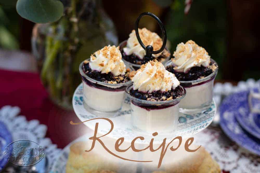 Four glass cups of dessert topped with whipped cream and crumbled nuts are displayed on a white cake stand, echoing the elegance you might find when serving an Iced Tea Recipe at a summer gathering. The word “Recipe” is overlaid on the image, while a floral arrangement softly decorates the blurred background.