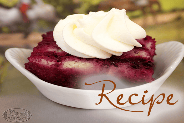 A slice of purple berry bread pudding with white whipped cream sits in a white dish. The word “Recipe” is written in cursive over the image, with a faint tea room logo in the corner.